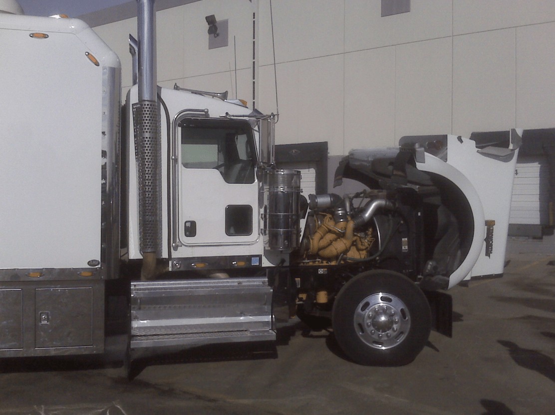 White semi-truck with open hood showing engine